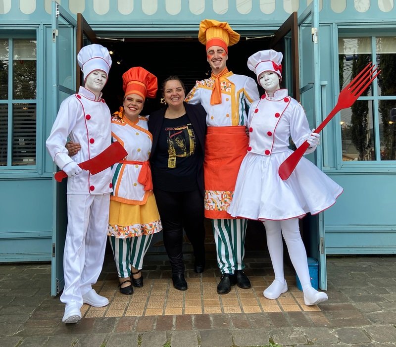 Lisi Berti centro com os personagens do Sabores de Canela chef Maria Risoto Canelone e estatuas humanas - Acontece Gramado